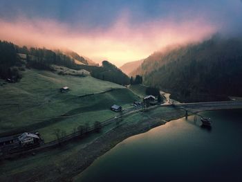 Aerial view of lake on mountain against sky during sunset