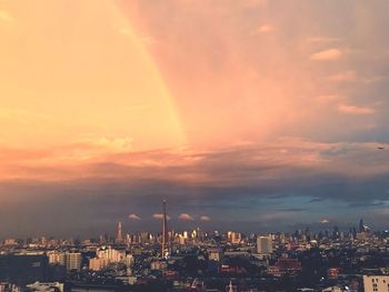 Aerial view of buildings against cloudy sky during sunset