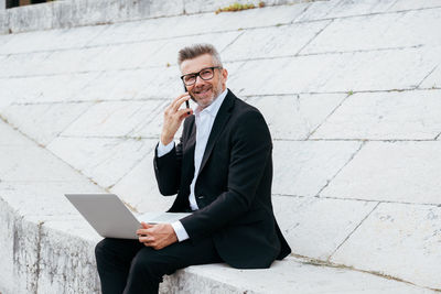 Man using mobile phone while sitting on floor