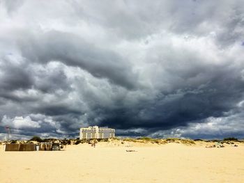 Scenic view of beach against cloudy sky