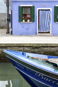 Boats moored in canal by building