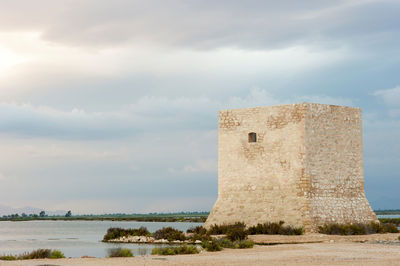 Historic building by sea against sky