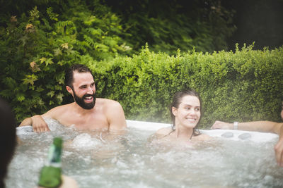 Young couple smiling in water at park