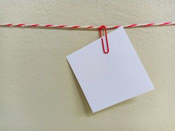 Close-up of clothespins hanging on rope against wall