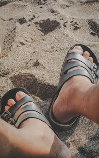 Low section of man relaxing on sand