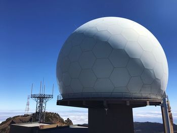 Low angle view of communications tower against clear blue sky