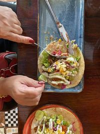 High angle view of hand holding food on table