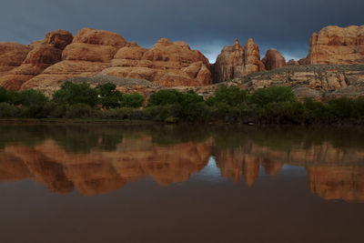 Reflection of rock formations in lake against sky