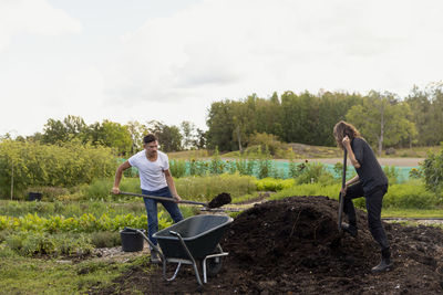 Young couple digging in garden