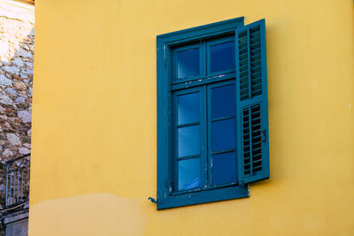 Close-up of yellow window on wall of building