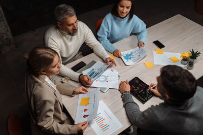 Diverse colleagues appreciate the presentation and discussing emotionally at contemporary office