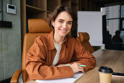 Portrait of young woman reading book at home