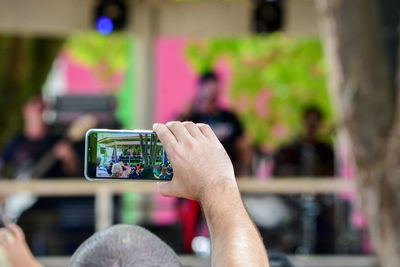 Midsection of woman photographing through mobile phone