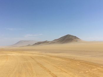 Scenic view of desert against blue sky