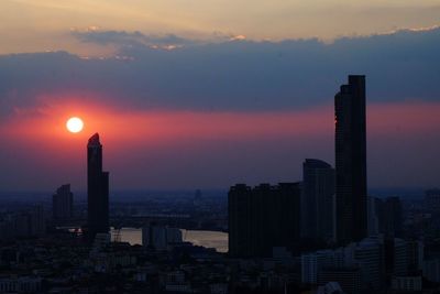 Modern buildings against sky during sunset