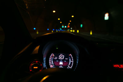 Illuminated light bulbs seen through car windshield at night