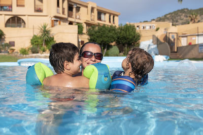 Single-parent family playing in the swimming pool. summer arrives in the northern hemisphere.