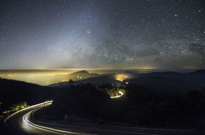 Scenic view of illuminated mountains against sky at night