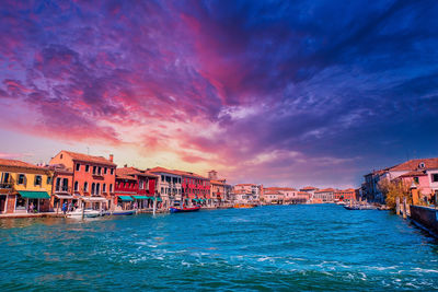 Scenic view of sea and buildings against sky during sunset