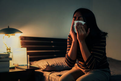 Midsection of woman sitting at home