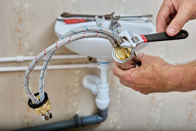 Cropped hand of man repairing bicycle handle