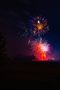 Low angle view of firework display at night