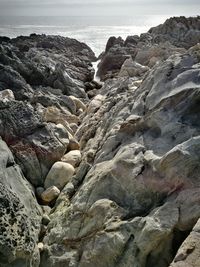 Rock formation on beach against sky