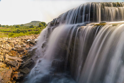 Scenic view of waterfall against sky