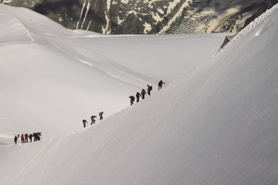 Hikers climbing snowcapped mountain