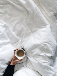 High angle view of coffee cup on bed