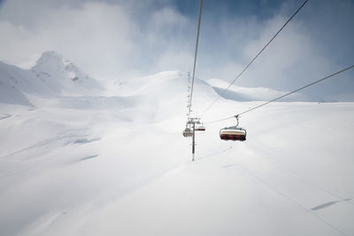 Chairlift in a ski resort, view from the funicular to the mountains and snow-covered fields for
