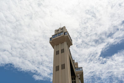 View from below the lacerda elevator against blue sky and white clouds. postcard