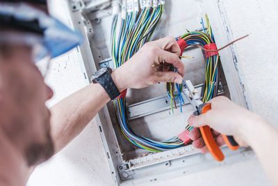 Close-up of man cutting cables