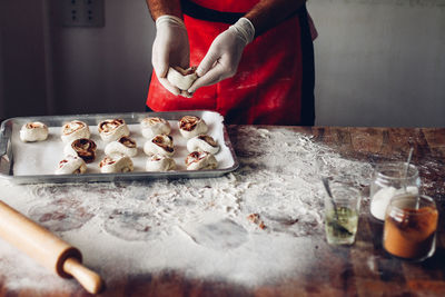 Midsection of man making cookies in kitchen at home