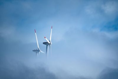 Low angle view of windmill against cloudy sky