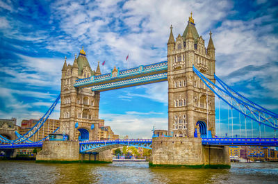 View of bridge over river against cloudy sky