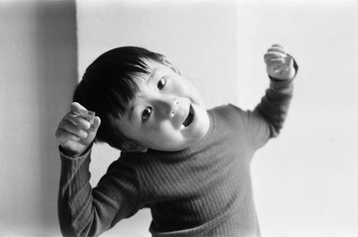 Portrait of young man standing against wall