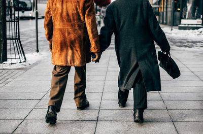 Low section of men walking on street