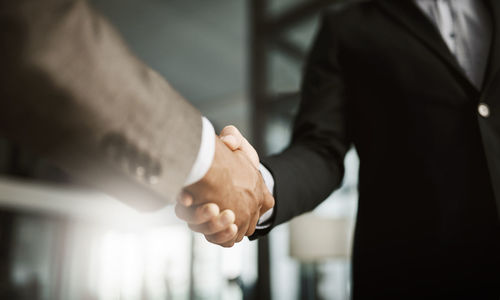 Midsection of businessman shaking hands