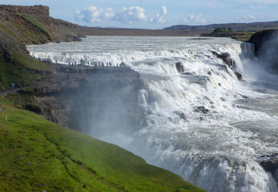 Scenic view of waterfall against sky