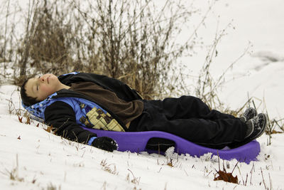 Boy taking a break from playing in the snow