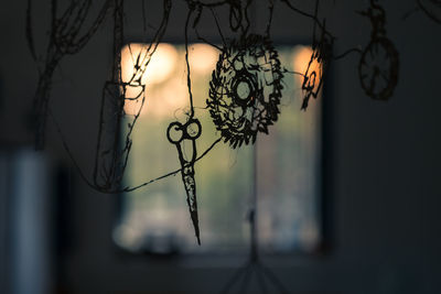 Close-up of silhouette shapes against window at sunset