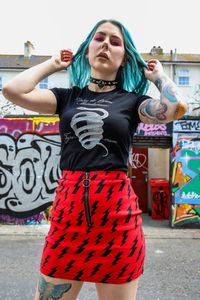 Young woman standing against graffiti in city