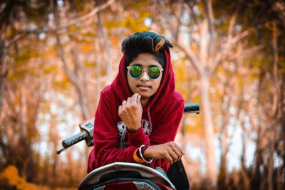 Portrait of young man riding motorcycle in forest