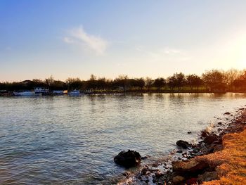 Scenic view of lake against sky at sunset