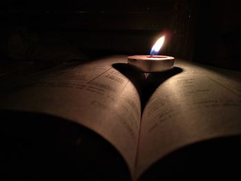 Close-up of lit candles on table in darkroom