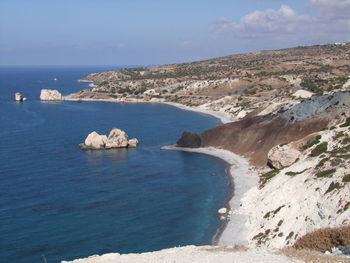 Scenic view of sea by mountains against sky