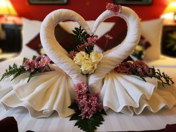 Close-up of flowers and towel decoration on bed