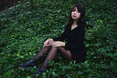 High angle portrait of woman wearing stockings sitting on plants at field