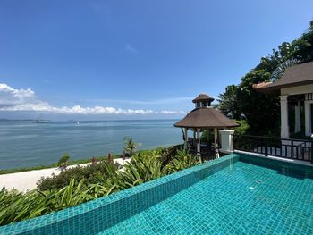 View of swimming pool by sea against blue sky